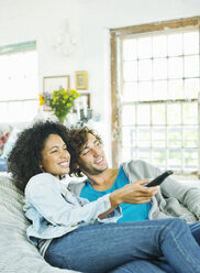 Couple watching television in beanbag chair - CAIF03196