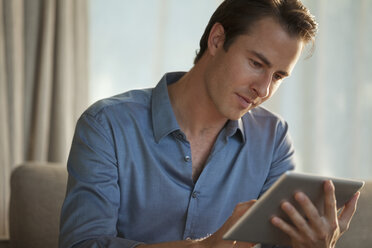 Geschäftsmann mit Tablet-Computer auf dem Sofa - CAIF03221