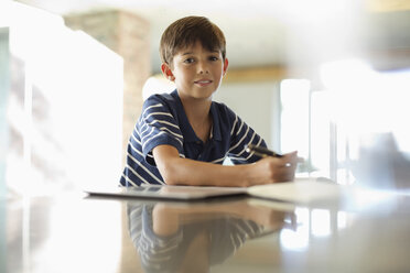 Boy doing homework at counter - CAIF03222