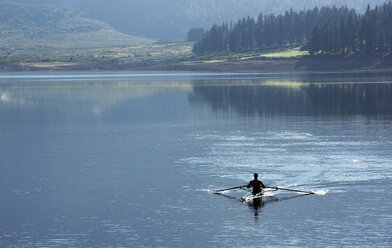 Man rowing scull on lake - CAIF03246