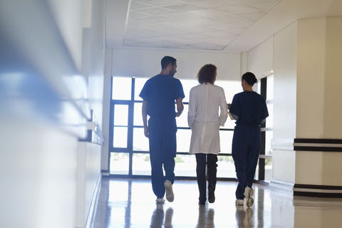 Krankenhauspersonal im Gespräch auf dem Flur, lizenzfreies Stockfoto