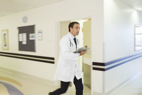 Doctor rushing in hospital hallway - CAIF03258