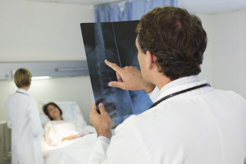 Doctor examining x-rays in hospital room - CAIF03280