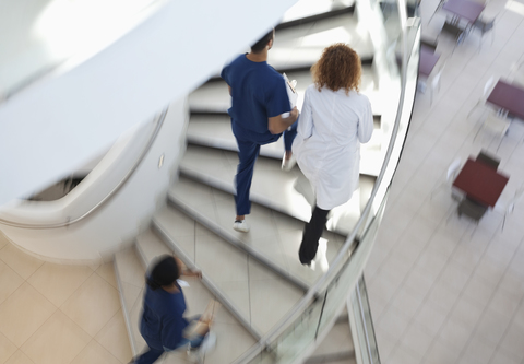 Krankenhauspersonal steigt die Wendeltreppe hinauf, lizenzfreies Stockfoto