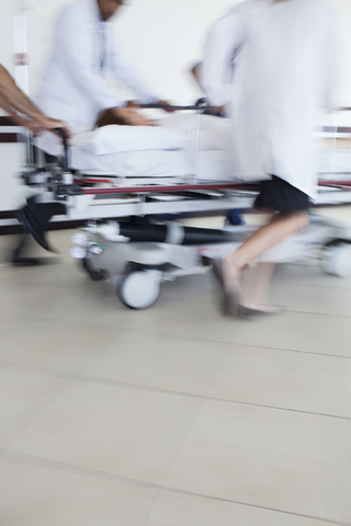 Krankenhauspersonal eilt mit dem Patienten in den Operationssaal, lizenzfreies Stockfoto