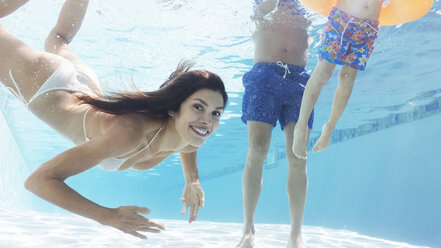 Familie schwimmt im Pool - CAIF03309