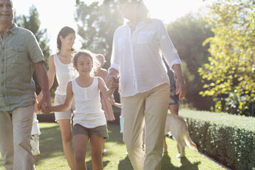 Familie beim gemeinsamen Spaziergang im Hinterhof - CAIF03323