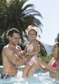 Family playing in swimming pool - CAIF03329