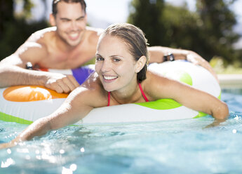 Couple relaxing in swimming pool - CAIF03360