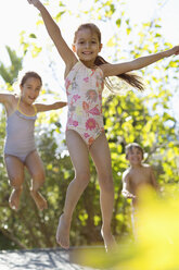 Kinder springen auf einem Trampolin im Freien - CAIF03362