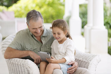 Älterer Mann und Enkelin benutzen Tablet-Computer - CAIF03386