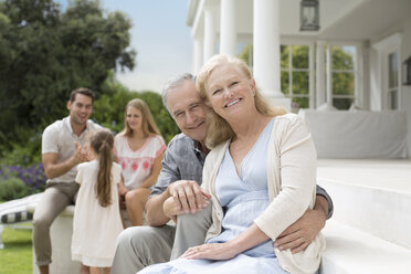 Older couple smiling on porch - CAIF03409