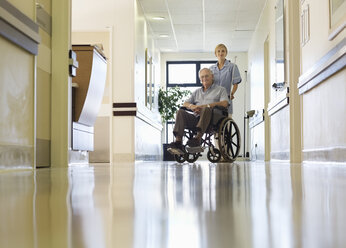 Krankenschwester rollt älteren Patienten ins Krankenhaus - CAIF03424