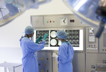 Surgeons examining x-rays in hospital - CAIF03426