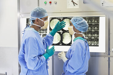 Surgeons examining x-rays in hospital - CAIF03445