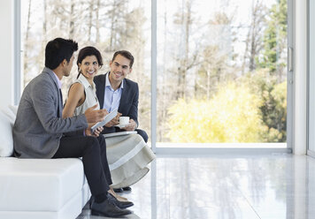 Business people talking on sofa in office - CAIF03484