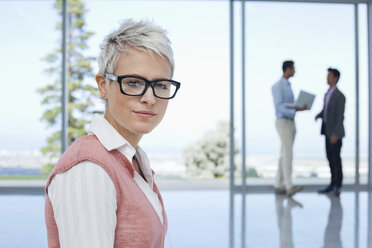 Businesswoman standing in office - CAIF03500