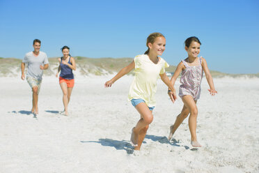 Family running together on beach - CAIF03577