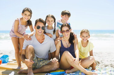 Porträt einer lächelnden Familie am Strand - CAIF03602