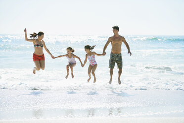 Familie springt in den Wellen am Strand - CAIF03611