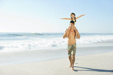Vater trägt Tochter auf den Schultern am Strand - CAIF03617