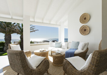 Wicker sofa and chairs on luxury patio - CAIF03697