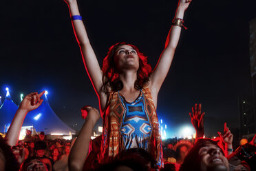 Jubelnde Frau auf den Schultern eines Mannes bei einem Musikfestival - CAIF03882