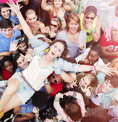 Enthusiastic woman crowd surfing at music festival - CAIF03888