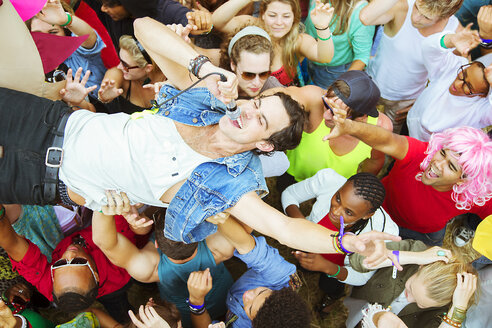 Performer mit Mikrofon beim Crowdsurfen auf einem Musikfestival - CAIF03910