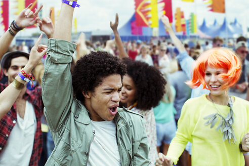 Freunde tanzen und jubeln auf einem Musikfestival - CAIF03959