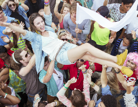 Frau beim Crowdsurfen auf einem Musikfestival, lizenzfreies Stockfoto