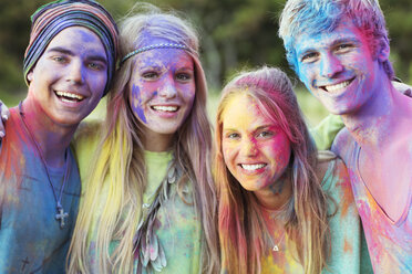 Close up portrait of friends covered in chalk dye at music festival - CAIF03974