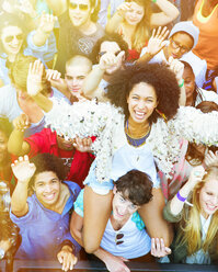 Portrait of cheering woman on manÍs shoulders at music festival - CAIF03989