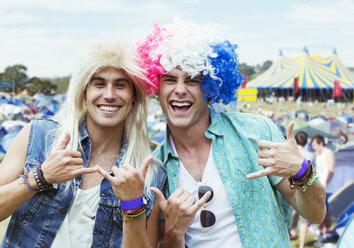 Portrait of men in wigs gesturing at music festival - CAIF04000