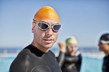 Triathleten in Neoprenanzügen mit Schutzbrille und Mütze - CAIF04051