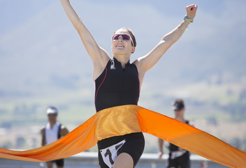 Runner crossing race finish line stock photo