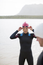 Triathlete adjusting goggles outdoors - CAIF04075