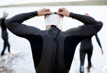 Triathlet beim Einstellen der Schwimmbrille vor dem Start des Rennens - CAIF04085