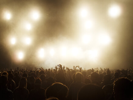 Silhouettierte Menschenmenge vor beleuchteter Bühne bei einem Musikfestival - CAIF04114