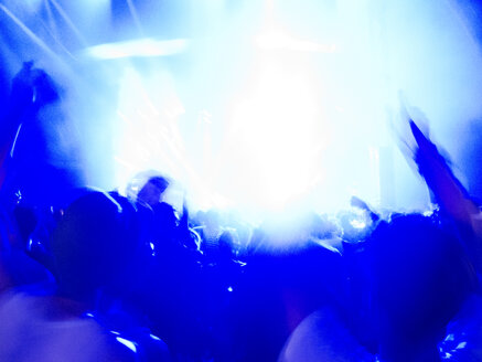 Silhouette einer Menschenmenge vor einer beleuchteten Bühne - CAIF04117