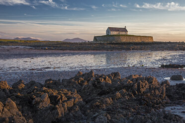 Tranquil medieval island church at low tide, St Cwyfans Church, Anglesey, Wales - CAIF04153