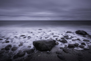 Tranquil overcast gray seascape and rocks on beach, Kalundborg, Denmark - CAIF04159