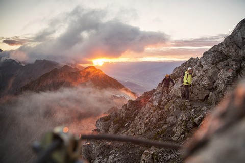 Österreich, Tirol, Innsbruck, Bergsteiger am Nordkette-Klettersteig bei Sonnenaufgang, lizenzfreies Stockfoto