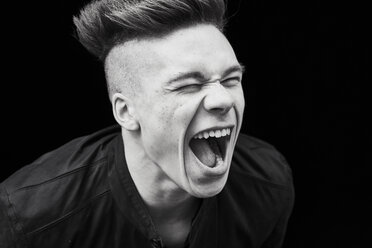 Black and white portrait of young man screaming - FMKF04888