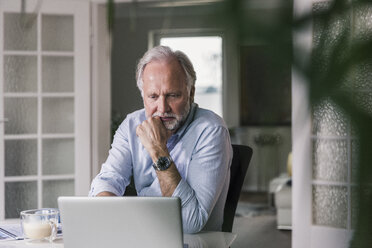 Portrait of mature man using laptop at home - UUF12937