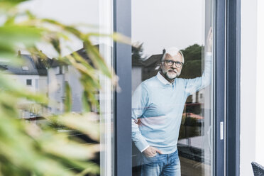 Älterer Mann schaut aus der Terrassentür - UUF12945