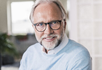Portrait of smiling mature man with grey hair and beard wearing glasses - UUF12947