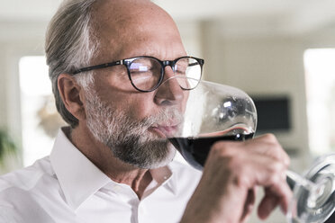 Porträt eines reifen Mannes, der ein Glas Rotwein trinkt - UUF12958