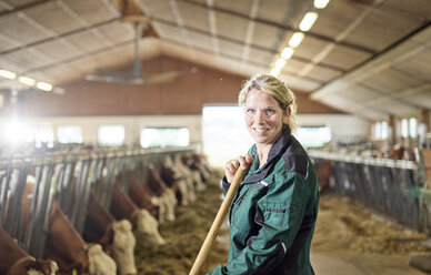 Porträt einer lächelnden Bäuerin im Stall auf einem Bauernhof - CVF00246