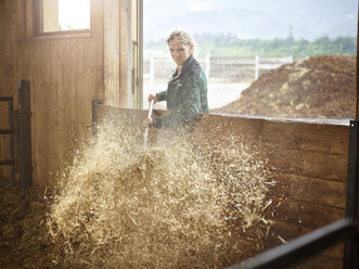 Female farmer working with straw on a farm - CVF00251